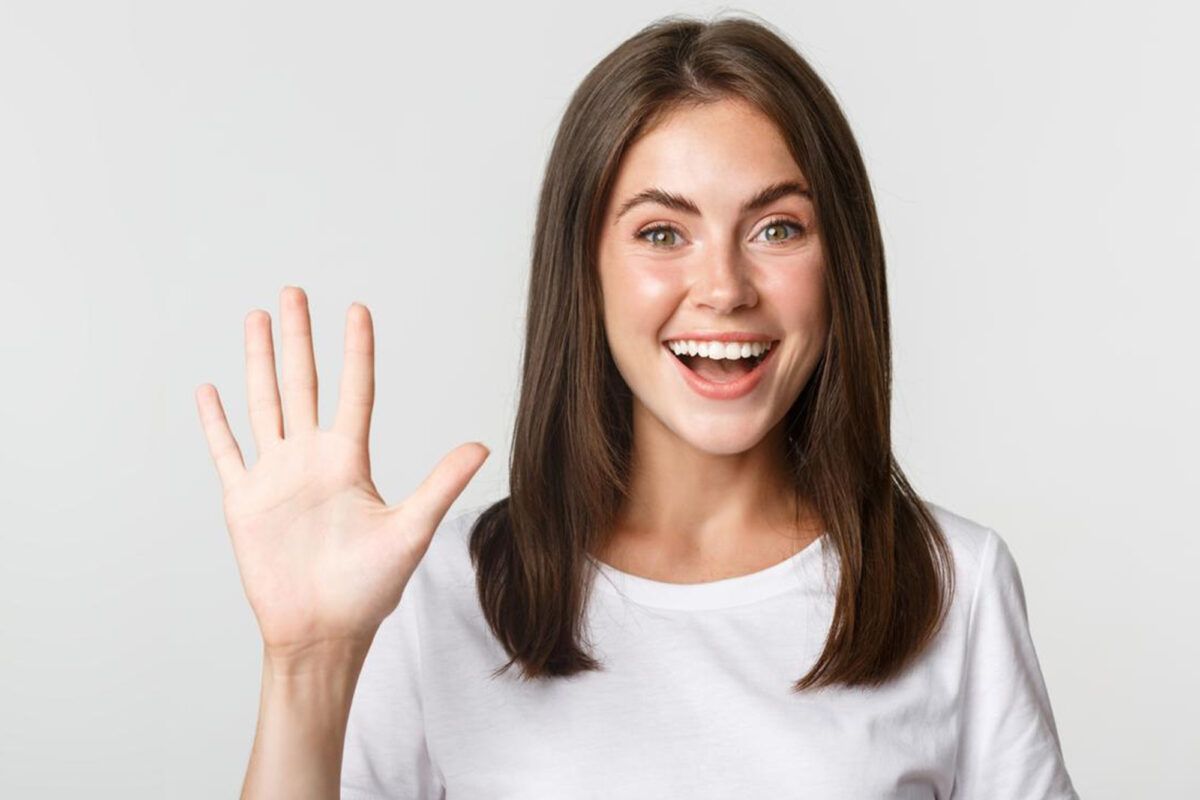 primer plano mujer joven atractiva alegre sonriendo mostrando cinco dedos fondo blanco 1
